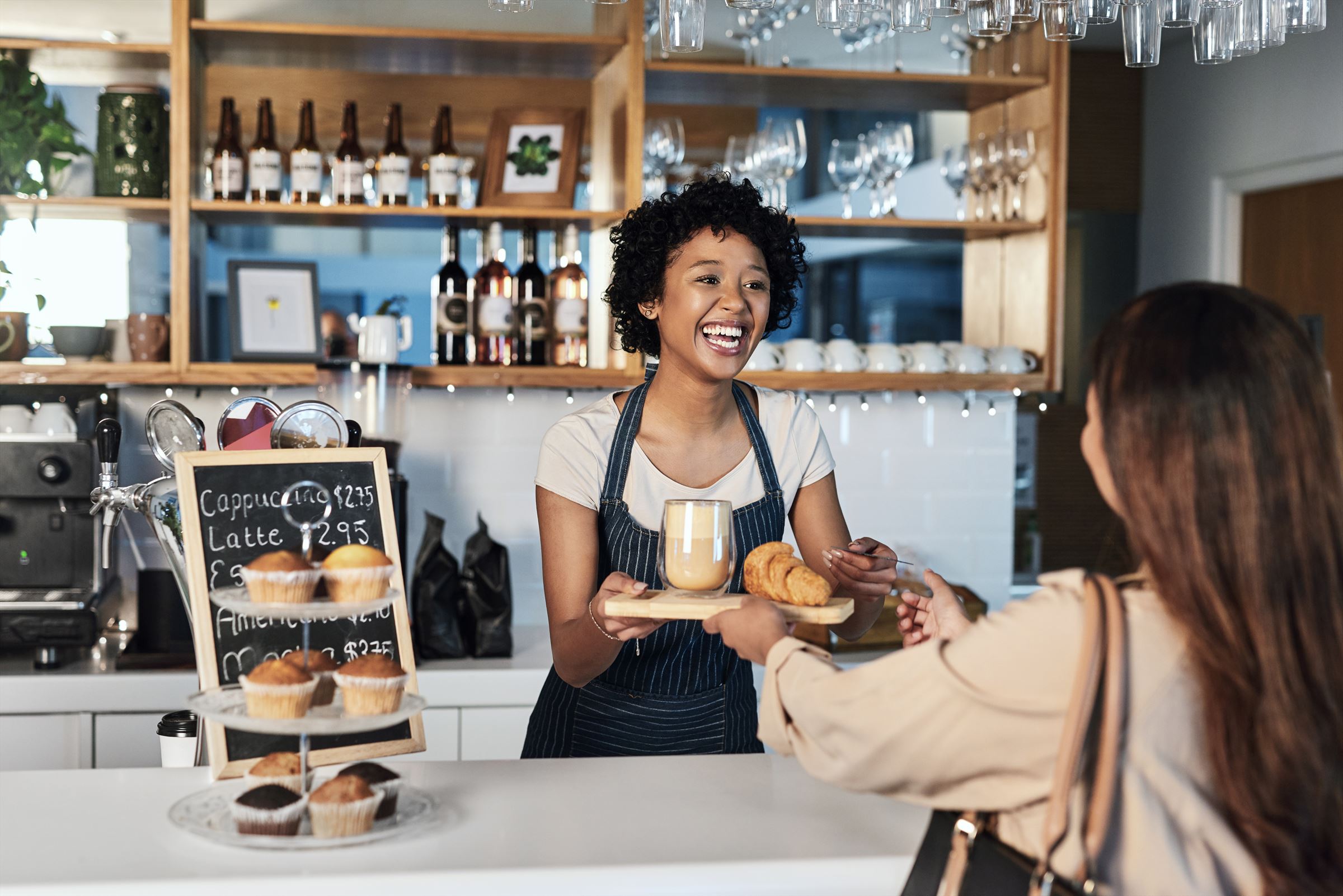 A café owner serving a customer at the counter